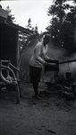Untitled (Woman Cooking at Rest Area in Woods) by Bert Call