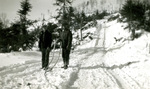 Two men standing at the foot of a steep slope display a snubbing rope